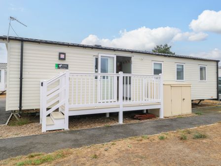 A caravan with a deck and storage shed at Haven Seashore, Ellerton Willerby Xtra, Great Yarmouth