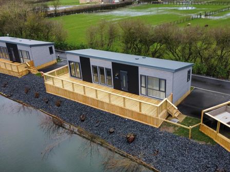 A lodge with a wooden deck by a water body at Malton 2Bed Lodge Sleeps 4 Pet Friendly in Malton
