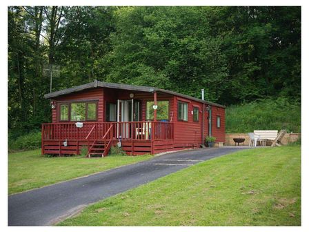 A cabin with a deck and outdoor seating in Builth Wells