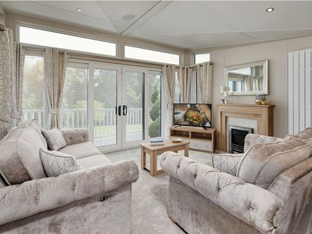 A living room with a sofa and television at 2Br Lodge Pool Fireplace PetsOK Parking in Goonhavern