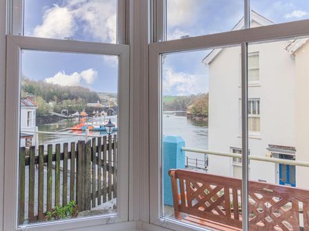 A view from a window showing a river and houses at The Slipway Fowey Harbour with Garden in Fowey