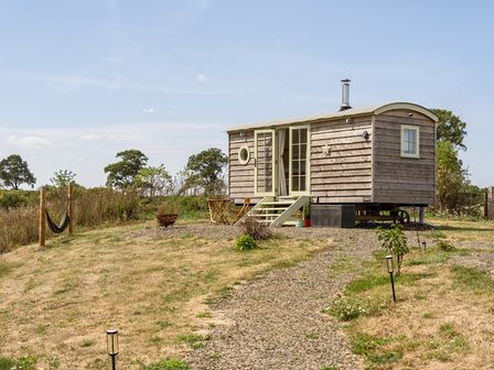 A tiny house with steps and outdoor seating at Cosy Luxury Owls Roost Hut with Private Hot Tub, Little Deptford Farm near Umberleigh