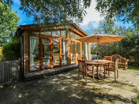 A garden with a wooden table and chairs at Oak Lodge Battisford near Stowmarket