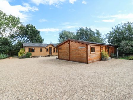 Two houses with a gravel driveway at Willow Lodge in Stowmarket