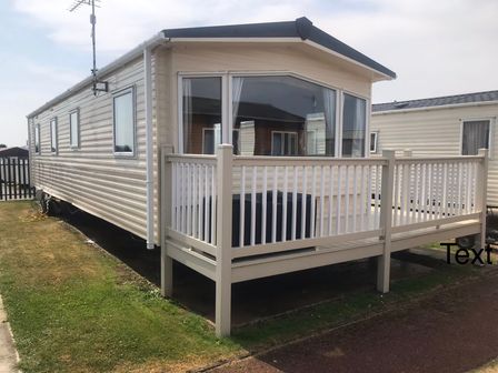 A caravan with a deck and railing at Golden Sands FSB38 in Rhyl