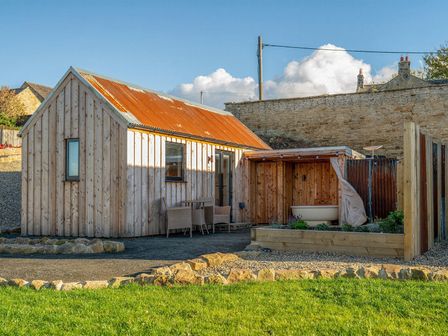 A wooden house with furniture and a bathtub in the outdoor area at 2 West Dunkirk Neuk in Humshaugh