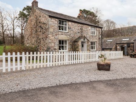 A house with a white fence and gravel pathway at Irt Cottage in Seascale