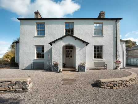 A house with a front door and windows at Three Mile House in Carnforth