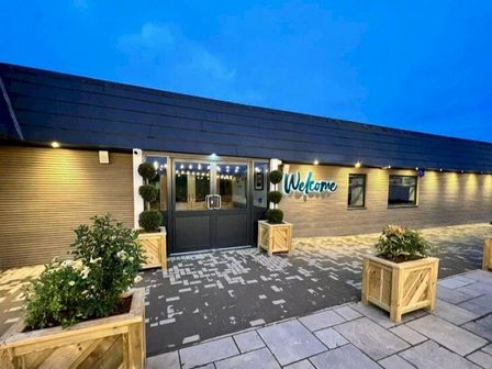 An entrance with double doors and a welcome sign at Glendale holiday park in Wigton