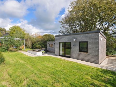 A garden with a wooden house at The Hyde in Clubworthy near Launceston