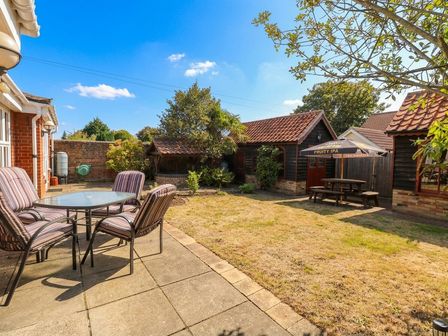 A garden with a table and chairs at The Mill House Apartment