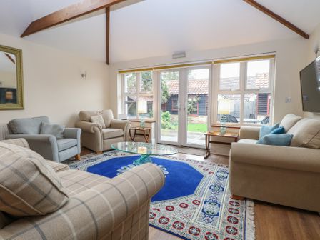 A living room with sofas and a coffee table at The Mill House Annexe in Oulton Broad