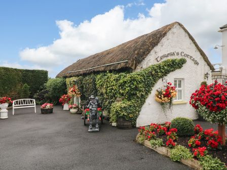 An outdoor area featuring flowers and a cottage sign at Teresa's Cottage