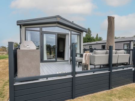 An outdoor area with decking and furniture at Lakewood Plot 8