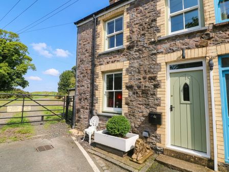 A house entrance with a stone wall and garden features at 11 Church Street Narberth