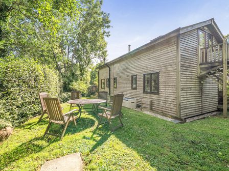 An outdoor area with a table and chairs at 3-Bed Barn Eco-Lodge on the Tarka trail East Yarde near Great Torrington