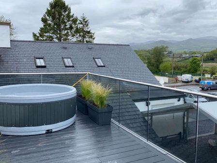 An outdoor area with a hot tub and planters at Snowdon Studio Apartment in Tal-y-cafn near Llandudno Junction