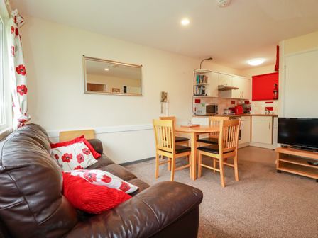 A living room with a dining table and sofa at Villa 12 near Camelford