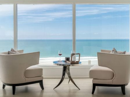 A living room with two armchairs and a coffee table at By The Sea in Newquay