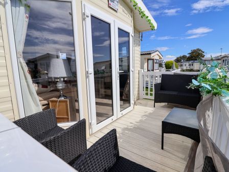 A balcony with chairs and a table at 15 Elm Crescent in Rhyl