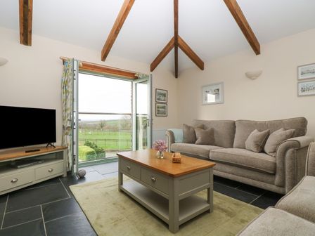 A living room with a sofa and television at Ash Cottage in Truro