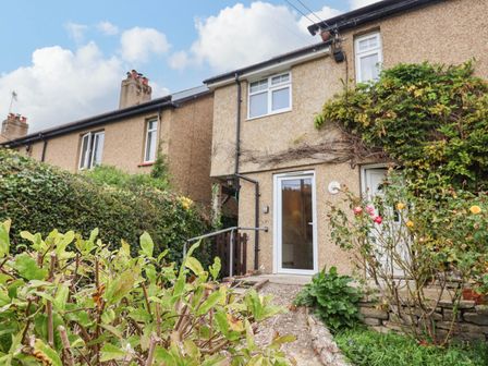An outdoor area with a house and garden at Coombe Cottage Apartment in Axmouth