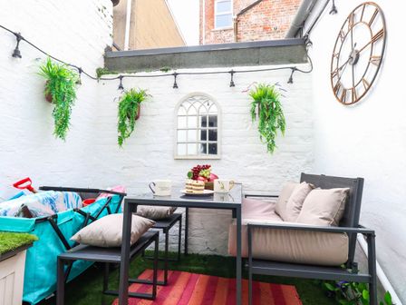 An outdoor patio with furniture and plants at Flat 1, 2 Wooperton Street Weymouth