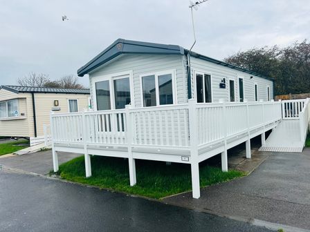 A mobile home with a deck and railing at Cala Gran - The Retreat 256 Boundary Road Fleetwood