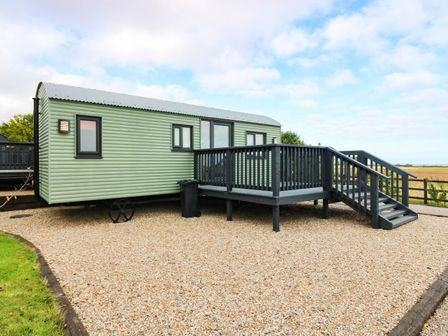 A static caravan with a deck and steps at Calendonia Hut West Mains near Haggerston