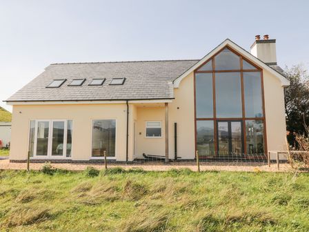 A house with large windows and a fence at Cae Mawr in Caernarfon