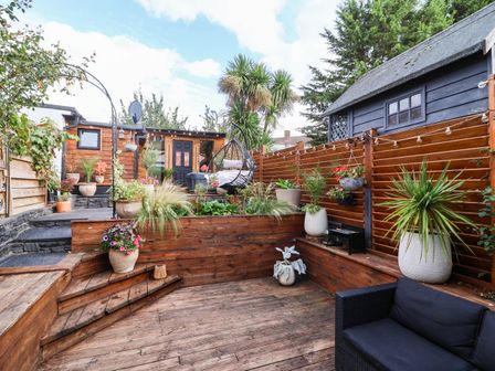 A garden with wooden deck and plants at Severnwolf House in Gloucester