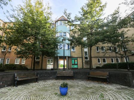 An outdoor area with trees and benches at 21 Ferrara Square Swansea