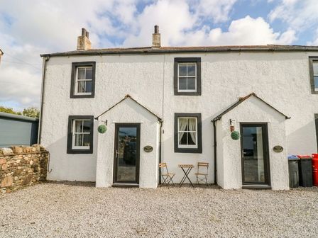 A house with a table and chairs in the outdoor area at Holly in Cleator