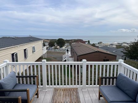 A deck with chairs overlooking the ocean at Club Sahara in Sandy Bay, Exmouth