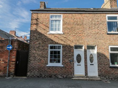 A brick house facade with windows and doors at Chapel Cottage in Filey
