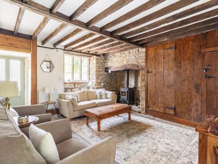 A living room with a sofa, coffee table, and fireplace at a property