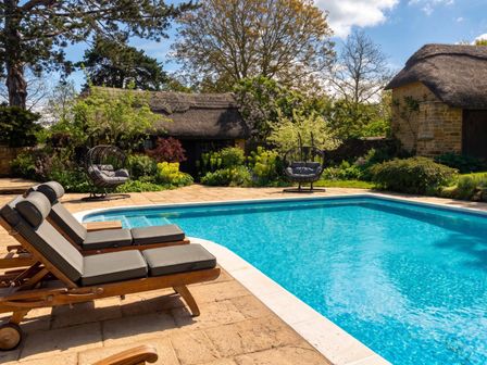 An outdoor area with a swimming pool and sun loungers at an unnamed location