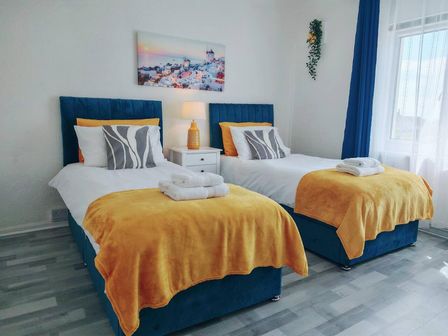 A bedroom with two beds and a bedside table at the property