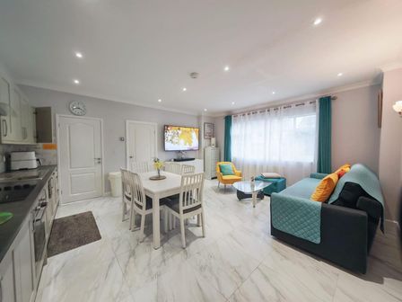 A kitchen with a dining table and chairs and a sofa at a property in an unknown location