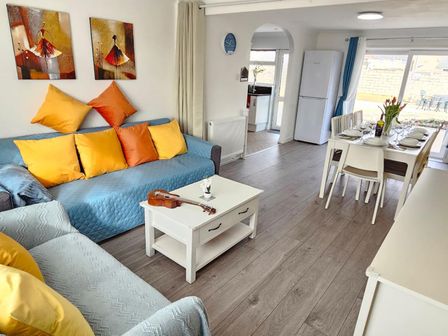 A living room with a sofa, coffee table, and dining area at the property