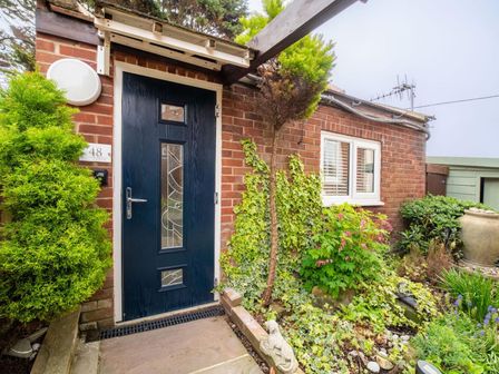An entrance with a blue door and garden at a residential property in