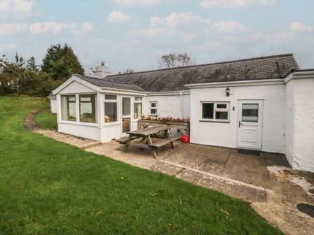 An outdoor area with a house and seating at Bryn Eithin in Penygroes