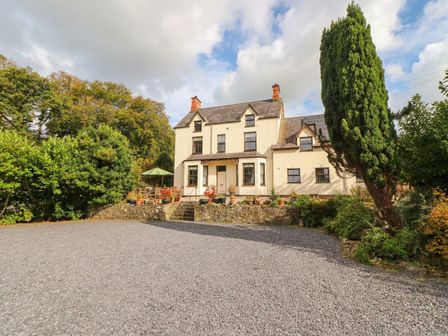 A house with a garden and gravel parking area at Craig Y Glyn