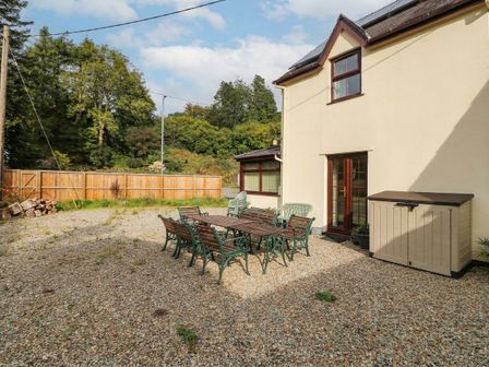An outdoor space with a table and chairs at Craig Y Glyn Cottage in Pwllheli