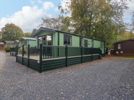 A mobile home with a porch and gravel surrounding at Lake It Easy in Troutbeck Bridge