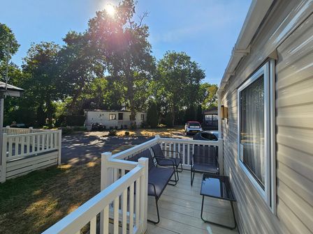 An outdoor area with a deck and chairs at a property