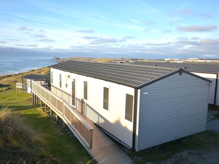 A mobile home with a deck overlooking the ocean at Perran Sands Holiday Park - 621 Chy-an-Mor, Perranporth