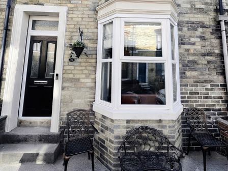 An outdoor view of a door and window with chairs at Jacks Place in Whitby