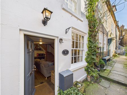 An entrance to a cottage with a sofa visible through the door at Delft Cottage in Robin Hood's Bay