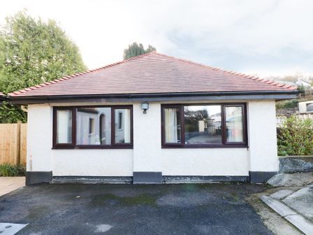 A single-story house with two windows and a tiled roof at The Garden Flat in Saundersfoot